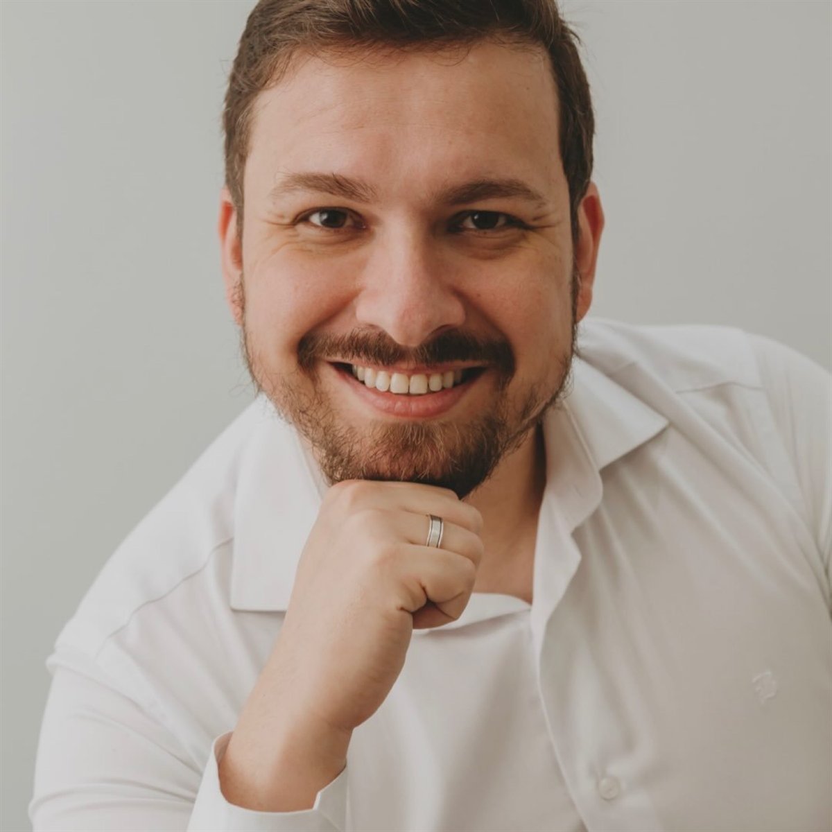 Dr. Kaio Cesar Grein, cirurgião-dentista, sorrindo de camisa branca